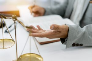 freelance legal consultant advises client on a lawsuit, discussing plans and rights while focusing on honesty and integrity, with legal books and scales at hand in a professional setting.