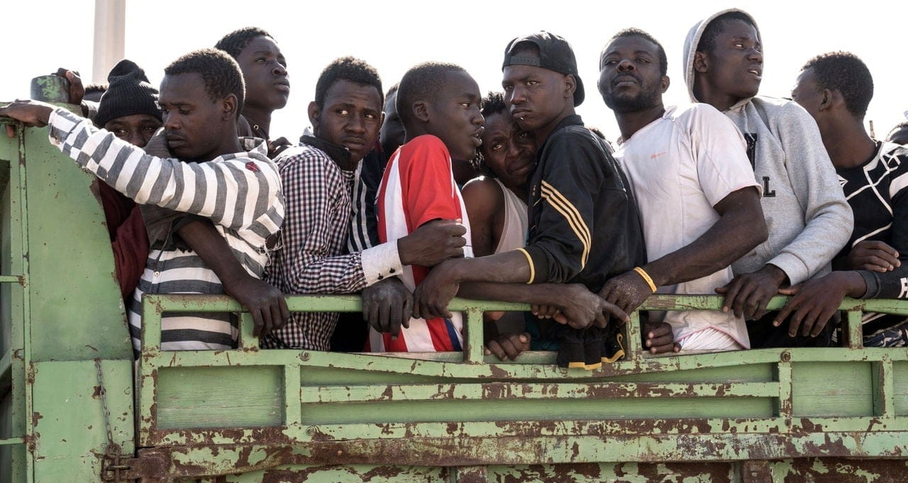 A group of migrants traveling in a crowded truck during a journey to seek asylum in Europe.