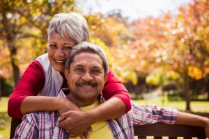 miling senior couple outdoors, representing New York’s expanded 2026 property tax relief for older homeowners