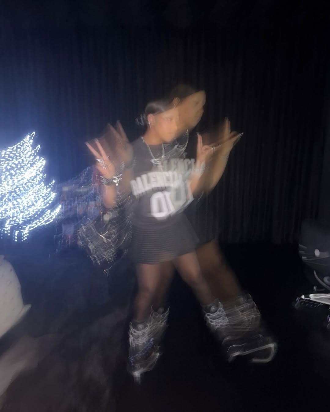 Blurry Instagram photo of North West posing indoors with holiday lights visible