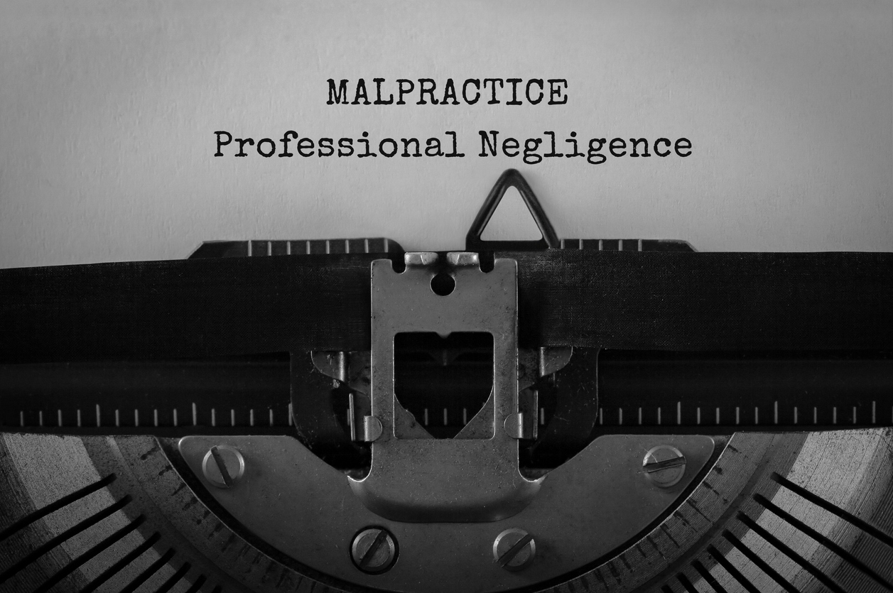 text malpractice professional negligence typed on retro typewriter