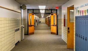 School hallway with subtle scale-of-justice overlay symbolizing Fourth Amendment limits and student privacy rights.