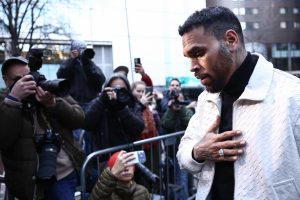 Chris Brown leaves Southwark Crown Court after a court hearing in London as photographers gather outside.